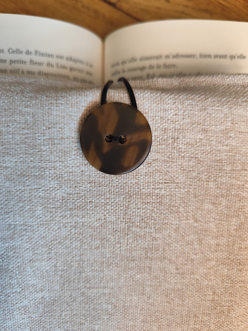 Détail du bouton écaille et de l'élastique de fermeture
